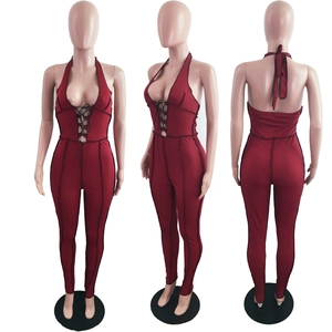 Detail view of burgundy ribbed halter jumpsuit with deep V-neck cross lacing and black seams