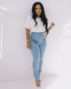 Close-up of high-waisted stretch denim jeans with curved stitching and front zipper