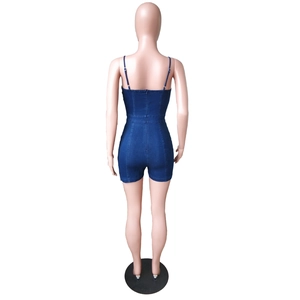 Detail view of denim romper showing thin straps and hidden back zipper closure on model
