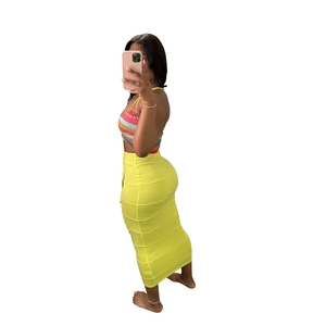 Detail of high-waisted yellow skirt with colorful halter top in knitted fabric