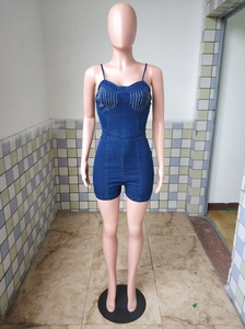 Detail of slim-fit denim romper featuring sparkling rhinestones and spaghetti straps