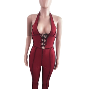 Detail of burgundy ribbed jumpsuit with black lace-up V-neck and contrast stitching