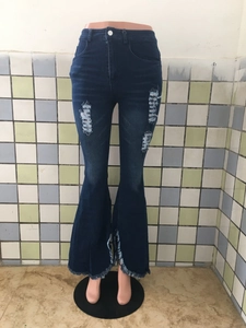 Detail einer Schlagjeans mit hoher Taille, Destroyed-Effekten und Fransen am Beinsaum