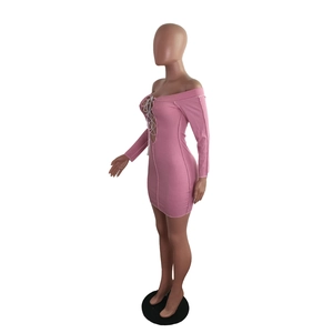 Detail of pink ribbed mini dress featuring lace-up V-neckline and textured slim-fit fabric