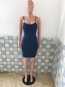 Detail view of denim bodycon dress featuring white polka dot print and slim fit cut