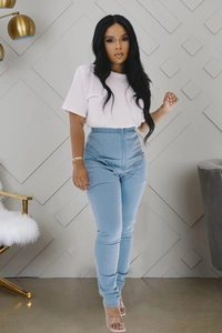 Detail of high waist light blue skinny jeans with elastic waistband and front metal zipper
