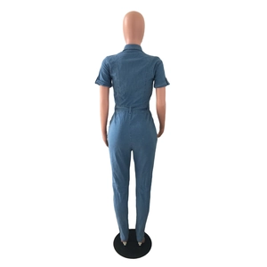 Rear view of light blue denim jumpsuit featuring waist stitching and slim fit tailoring