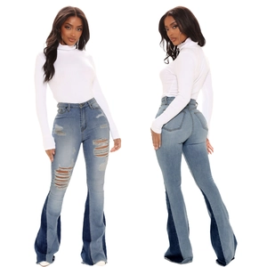 Detail of high-waisted flared jeans with distressed rips and contrast color block hem