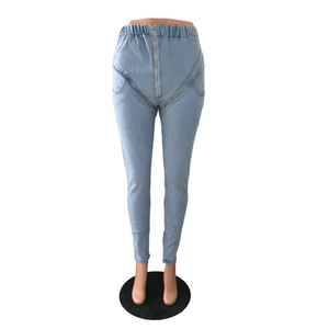 Detail of high waisted skinny jeans with elastic waistband and gold zipper in light blue