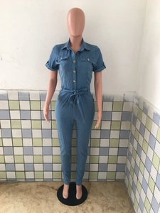 Short sleeve denim jumpsuit featuring a button-up front with waist tie and chest pockets