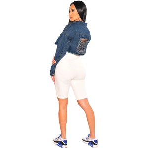 Vue arrière de la veste courte en jean déchirée avec franges et short blanc taille haute