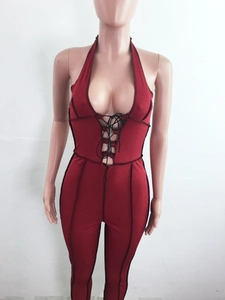 Detail of burgundy ribbed jumpsuit with contrast black stitching and front lace-up design