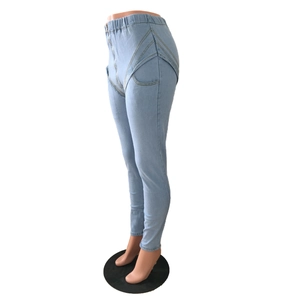 Detail of high waist light blue stretch denim pants with decorative curved stitching