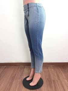Détail de la fermeture éclair latérale sur un jean skinny bleu clair dégradé