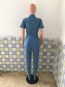 Detail view of the back of a blue denim jumpsuit with short sleeves and belt loops