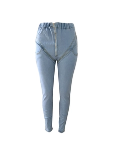 Detail of high waist light blue stretch skinny jeans featuring curved decorative stitching