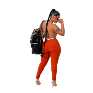Women high waist orange skinny stretch jeans paired with a white backless halter top