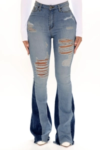 Detail of high waisted flared jeans featuring distressed ripped thighs and patchwork hem