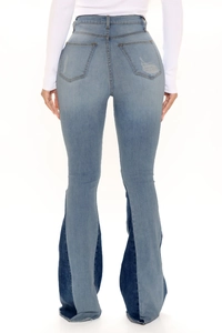 Detailed back view of high-waisted flared jeans with contrast denim patchwork and ripped pocket