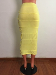 Detail showing the textured horizontal stitching and bright yellow fabric of the midi skirt