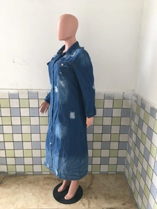 Détail d'une robe longue en jean délavée avec déchirures et boutons métalliques