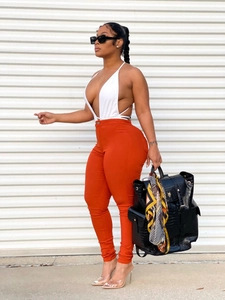 Outdoor street fashion featuring white backless halter top and red slim fit trousers