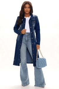 Detailed view of long denim trench coat with ripped effects and high waisted flare jeans