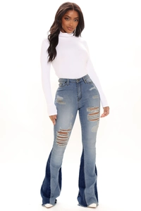 Close-up of high waist ripped bell-bottom jeans with two-tone denim stitching details