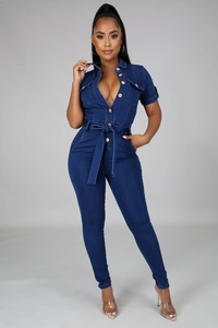 Detail of dark blue denim jumpsuit featuring button closure and self-tie belted waistline