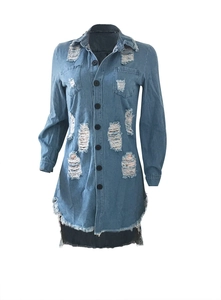 Detailed close-up of distressed denim dress with ripped holes and frayed fringe hemline