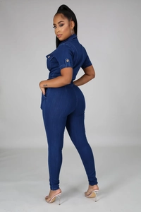 Detail of short sleeves and chest pocket with wooden button on dark blue denim jumpsuit