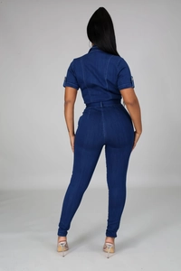 Rear view detail of short sleeve denim jumpsuit with white contrast stitching and tie waist