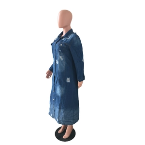 Gros plan du manteau en denim vieilli avec trous déchirés et détails vintage lavés