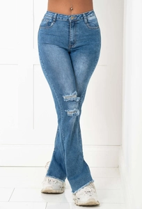Detail showing distressed knee rips and frayed hem on washed blue flare jeans
