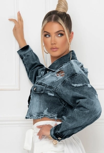 Détail de la veste courte en jean avec délavage vintage et finitions effilochées mode