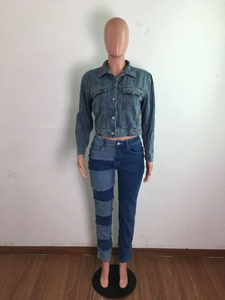 Détail du design en patchwork de denim sur le jean taille haute et la veste courte en jean