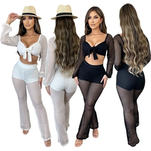 Two-piece mesh beach set featuring lace-up long sleeve crop top and flared trousers