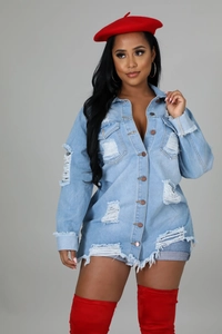 Detail of light blue distressed denim jacket featuring frayed tassels and metal buttons