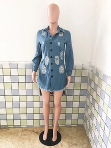 Detail of light blue denim shirt dress showing distressed holes and frayed hemline