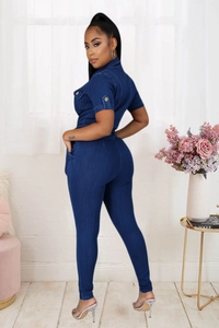 Detail of slim-fit dark blue denim jumpsuit with short sleeves and buttoned chest pockets