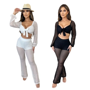 Mesh two-piece set featuring tie-front long sleeve crop top and flared pants in white and black