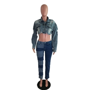 Détail d'une veste en jean courte délavée et d'un jean skinny avec patchwork bleu