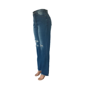 Detail of high waisted flare jeans with distressed ripped knees and raw fringe hemline