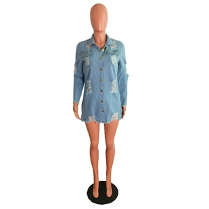 Detail of light blue denim shirt dress featuring distressed holes and fringed hemline