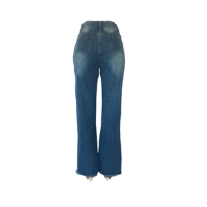 Detail of blue flared jeans showing back pockets and raw frayed hem design