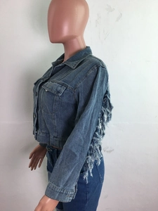 Vue détaillée d'une veste en jean avec des franges bohèmes sur les manches et le dos