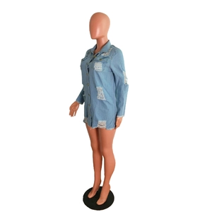 Detail of light blue distressed denim dress with ripped holes and fringe on a model
