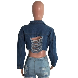 Détail de veste en jean courte avec dos déchiré effet délavé et finitions à franges