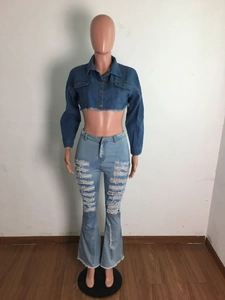 Détail de la veste en jean courte à franges et du jean évasé taille haute usé