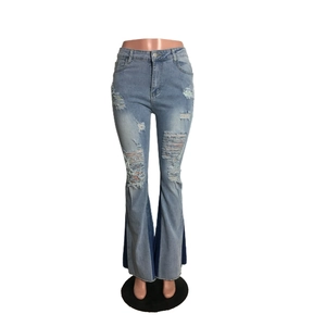 Detail of high waisted flare jeans featuring distressed ripped holes and two-tone denim hem